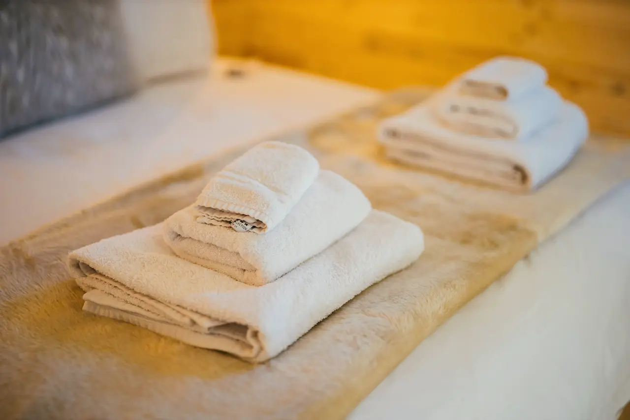 Serviettes pliées sur un lit fait, comme à l'hôtel